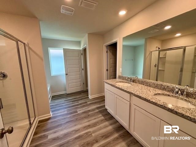 22215 Aleutian Avenue Foley, AL 36535 - Photo 8 of 34 Bathroom featuring vanity, hardwood / wood-style flooring, and an enclosed shower
