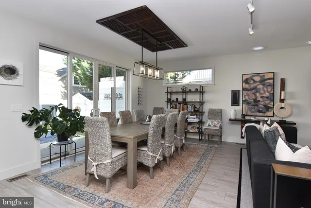 a kitchen with granite countertop a table chairs sink and refrigerator
