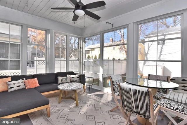 a living room with furniture a chandelier and a floor to ceiling window