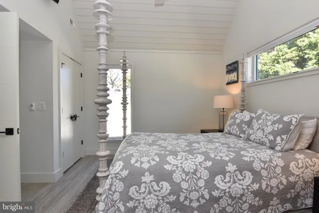 a bedroom with a bed and a painting on the wall