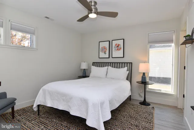 a bathroom with a granite countertop sink a toilet a mirror and shower