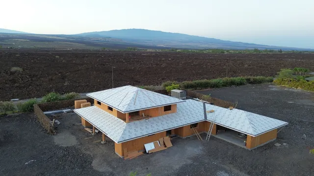 an aerial view of a house with a yard lake view and mountain view in back