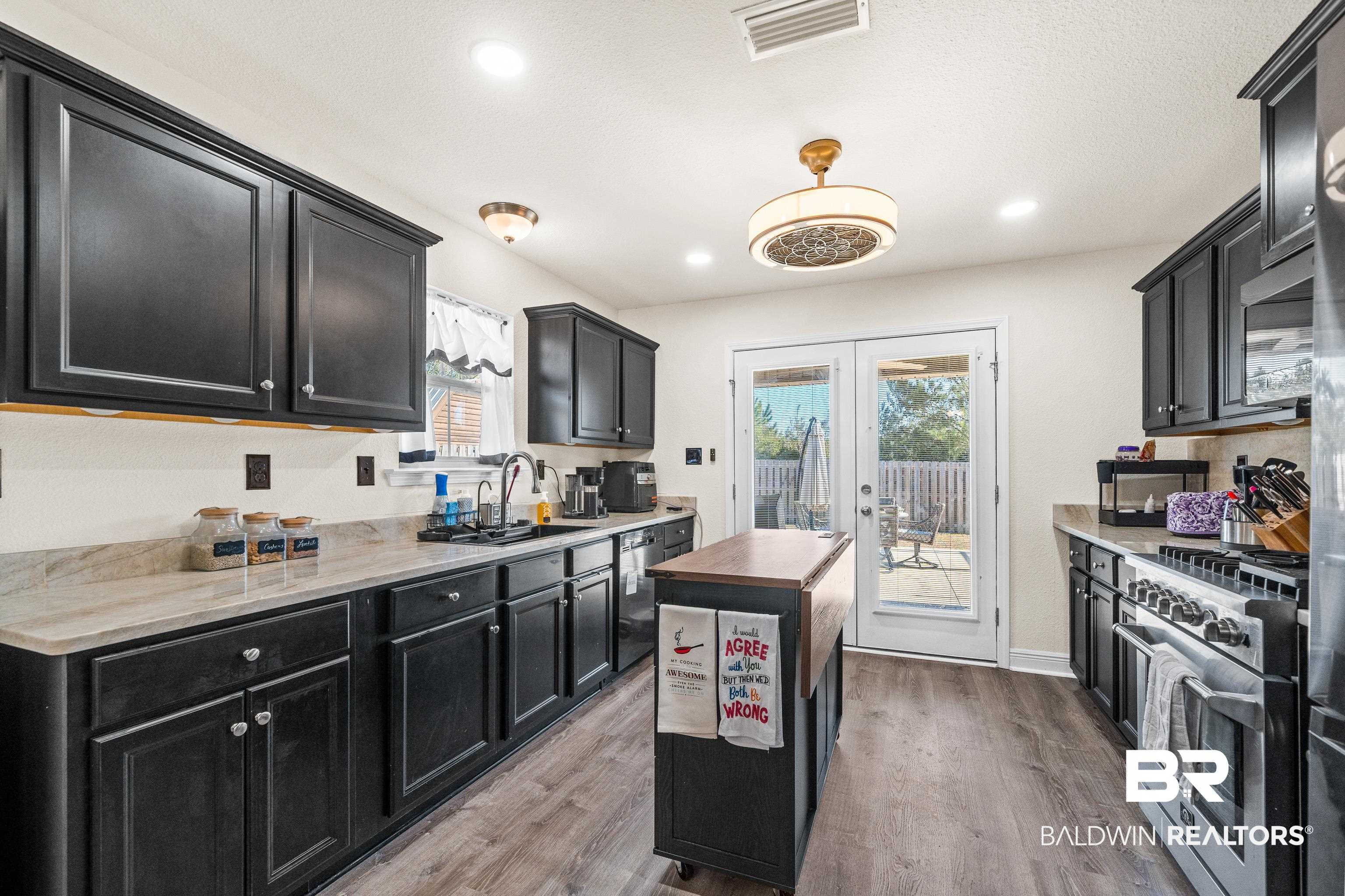 17100 Cold Mill Loop Foley, AL 36535 - Photo 7 of 27 Kitchen featuring dark cabinetry, butcher block counters, appliances with stainless steel finishes, light wood finished floors, and recessed lighting