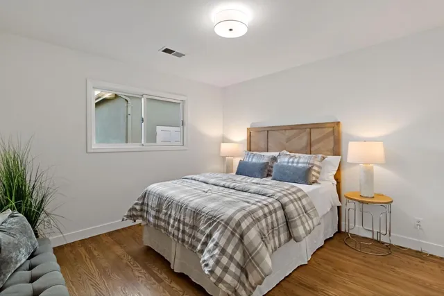a bedroom with a bed and wooden floor