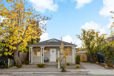 a front view of a house with a tree