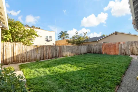 a view of a backyard with wooden fence