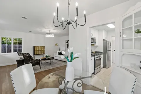 a living room with furniture a chandelier a dining table and chairs