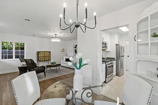 a living room with furniture a chandelier a dining table and chairs