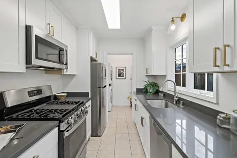 a kitchen with stainless steel appliances granite countertop a stove a sink and a microwave