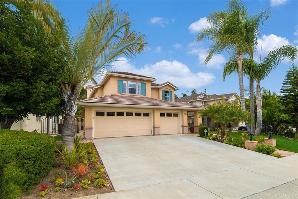 a front view of a house with a yard and potted plants
