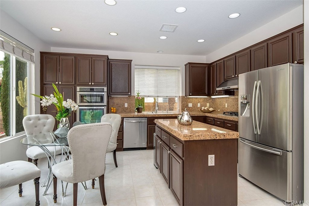 27952 Rural Lane Laguna Niguel, CA 92677 - Photo 6 of 28 a kitchen with stainless steel appliances granite countertop a refrigerator a stove a sink a dining table and chairs