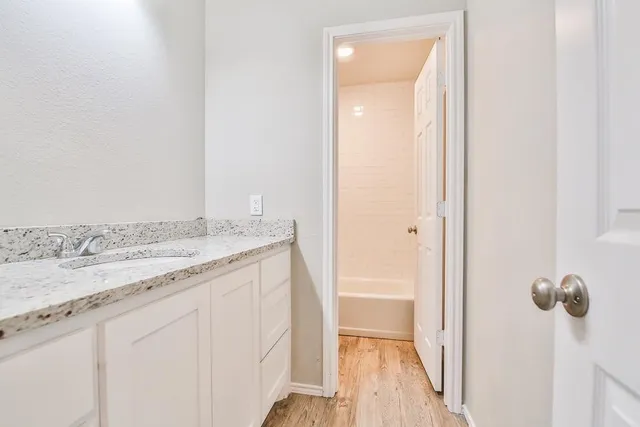 a bathroom with a granite countertop sink and a mirror