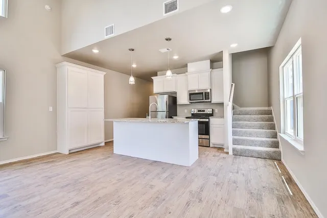 a view of kitchen with wooden floor and electronic appliances