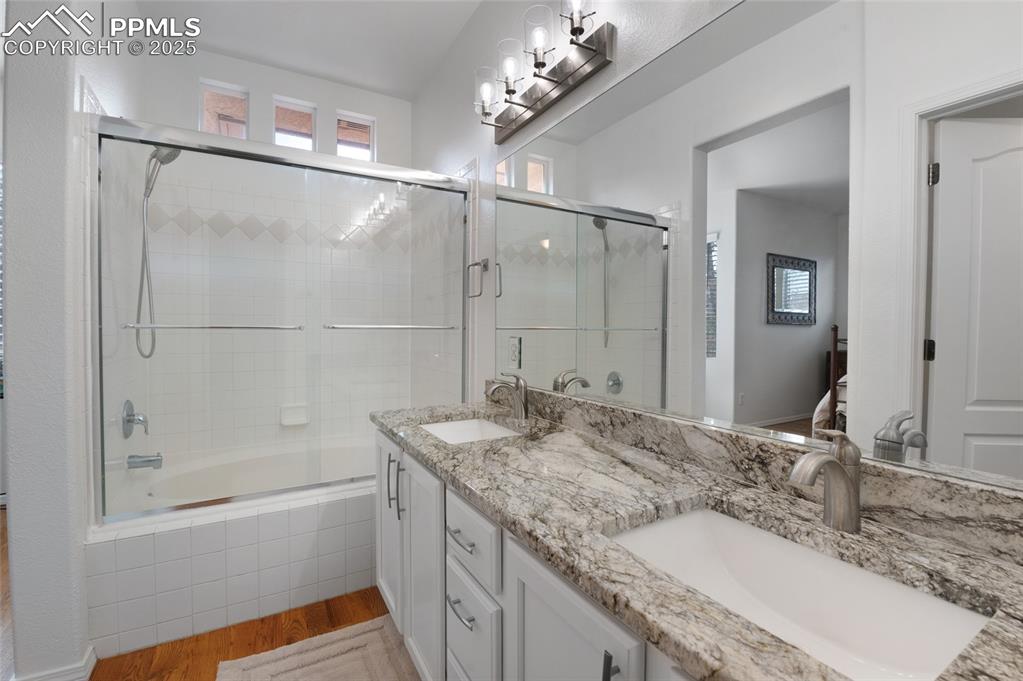 3294 Apogee View Colorado Springs, CO 80906 - Photo 17 of 35 a bathroom with a granite countertop bathtub a sink and mirror
