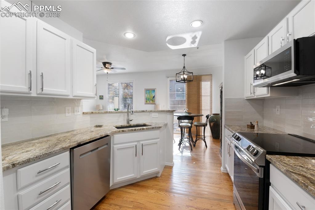 3294 Apogee View Colorado Springs, CO 80906 - Photo 5 of 35 a kitchen with stainless steel appliances granite countertop a sink a stove and cabinets