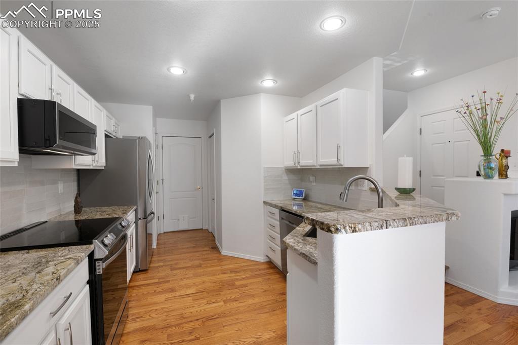 3294 Apogee View Colorado Springs, CO 80906 - Photo 6 of 35 a kitchen with stainless steel appliances granite countertop a sink stove and refrigerator