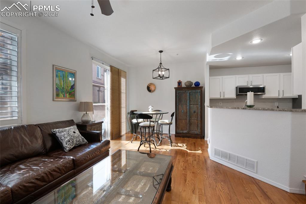 3294 Apogee View Colorado Springs, CO 80906 - Photo 9 of 35 a living room with stainless steel appliances kitchen island granite countertop furniture and a wooden floor