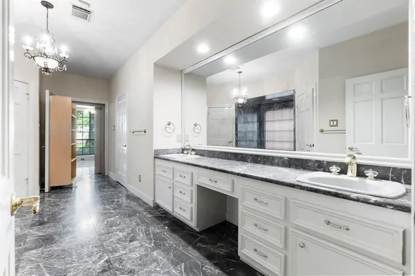 a spacious bathroom with a granite countertop sink a mirror and a shower