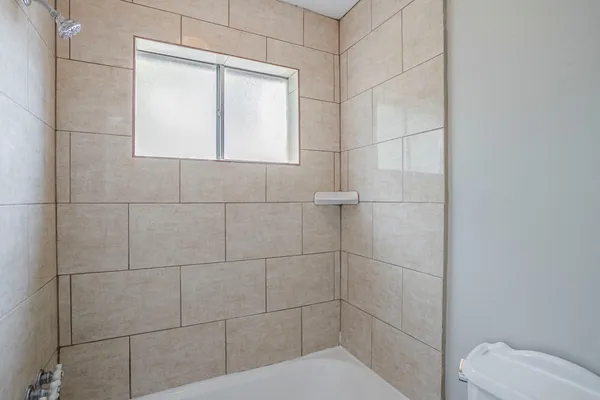 a bathroom with a toilet and a shower