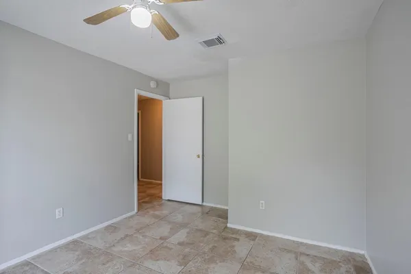 an empty room with chandelier fan