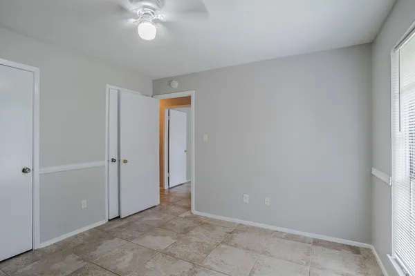 a view of an empty room and chandelier fan
