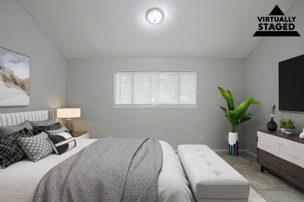 a bedroom with a bed and a potted plant