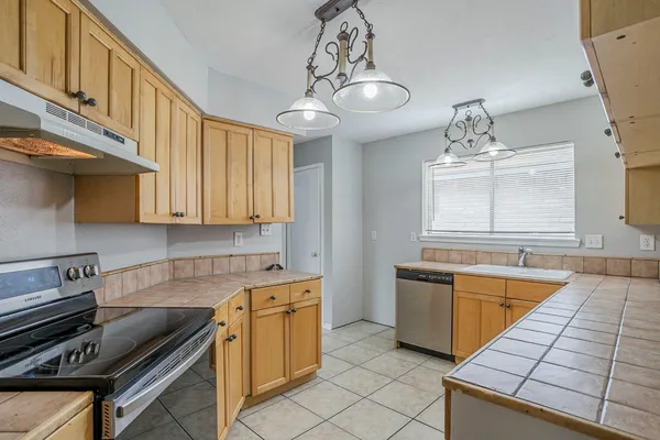 a kitchen with a sink appliances and cabinets