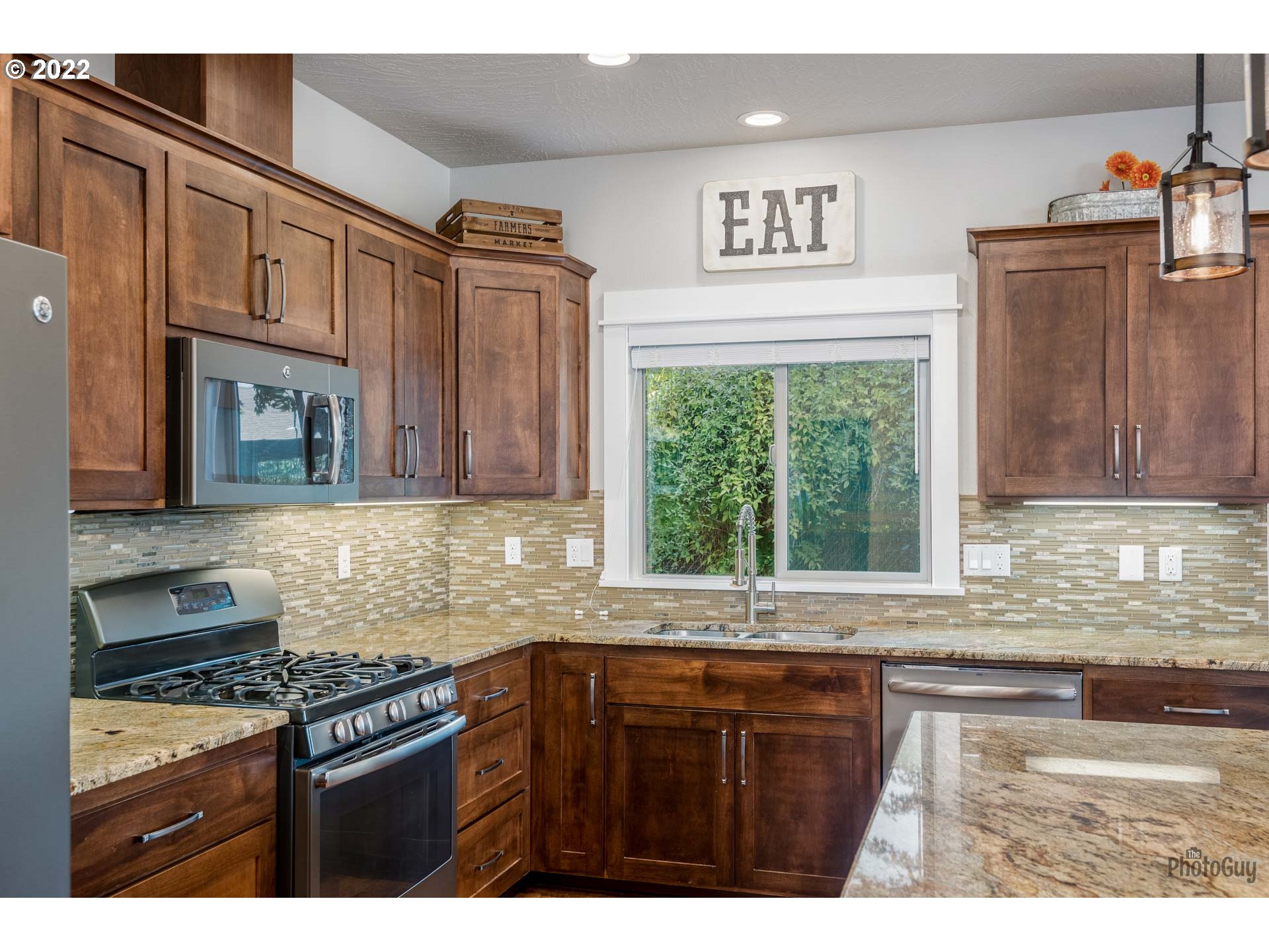 853 67th Place Springfield, OR 97478 - Photo 10 of 32 a kitchen with stainless steel appliances granite countertop a stove a sink and a microwave