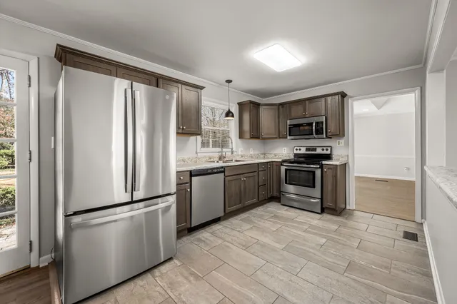 a kitchen with a refrigerator a microwave a sink and cabinets