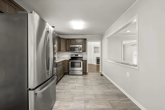 a kitchen with granite countertop a refrigerator and a sink