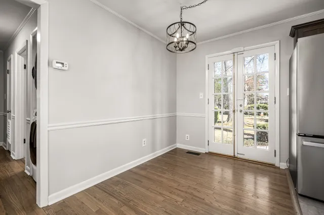 a view of empty room with wooden floor and window