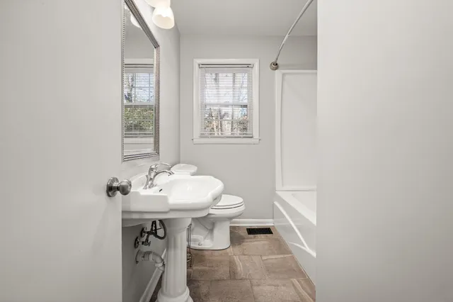 a bathroom with a sink a toilet and a window