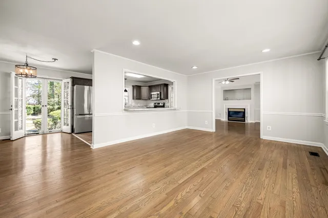 a view of empty room with wooden floor and fireplace