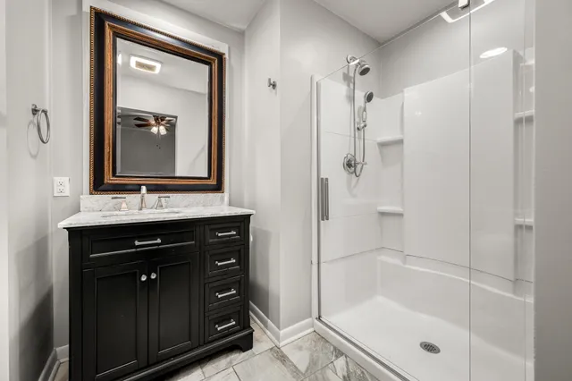 a bathroom with a shower sink vanity and mirror