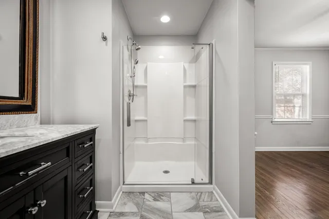 a bathroom with a granite countertop sink a shower and a mirror