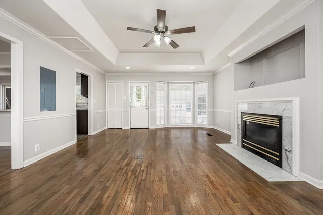 a view of empty room with wooden floor and fireplace