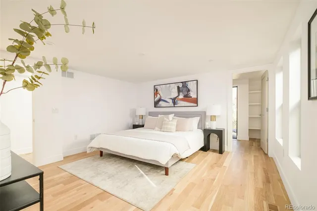 a bedroom with a bed and a painting on the wall