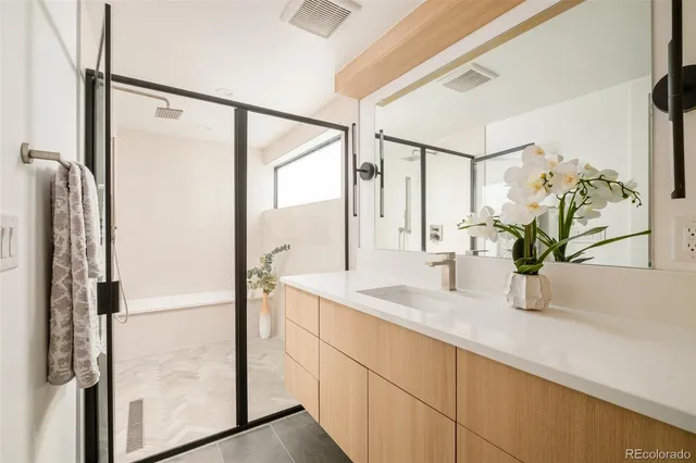 a bathroom with a sink a mirror and a shower