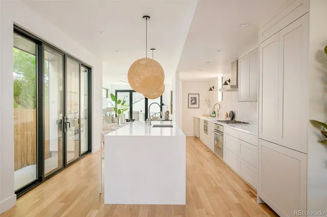 a large kitchen with lot of counter space and wooden floor