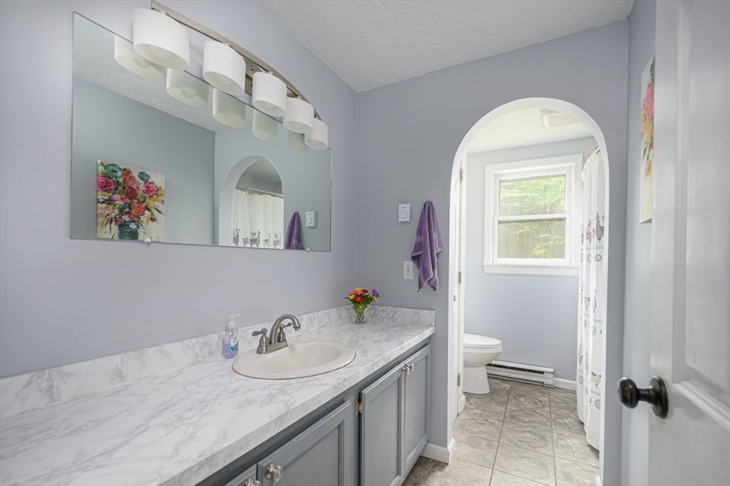 23 Pikes Hill Road Sterling, MA 01564 - Photo 6 of 27 a bathroom with a granite countertop sink a toilet and a mirror