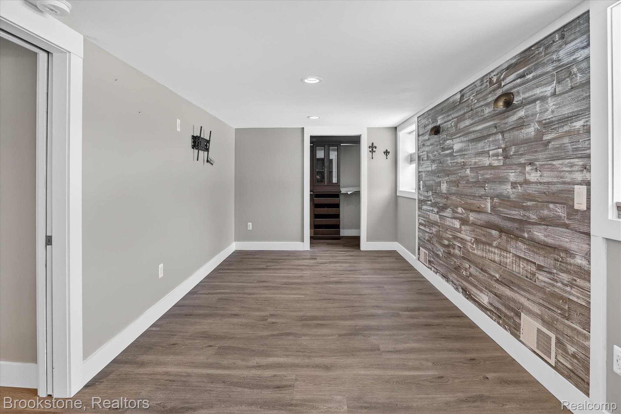 2450 North Lakeshore Road Carsonville, MI 48419 - Photo 23 of 27 Empty room with wood finished floors, an accent wall, recessed lighting, and wood walls