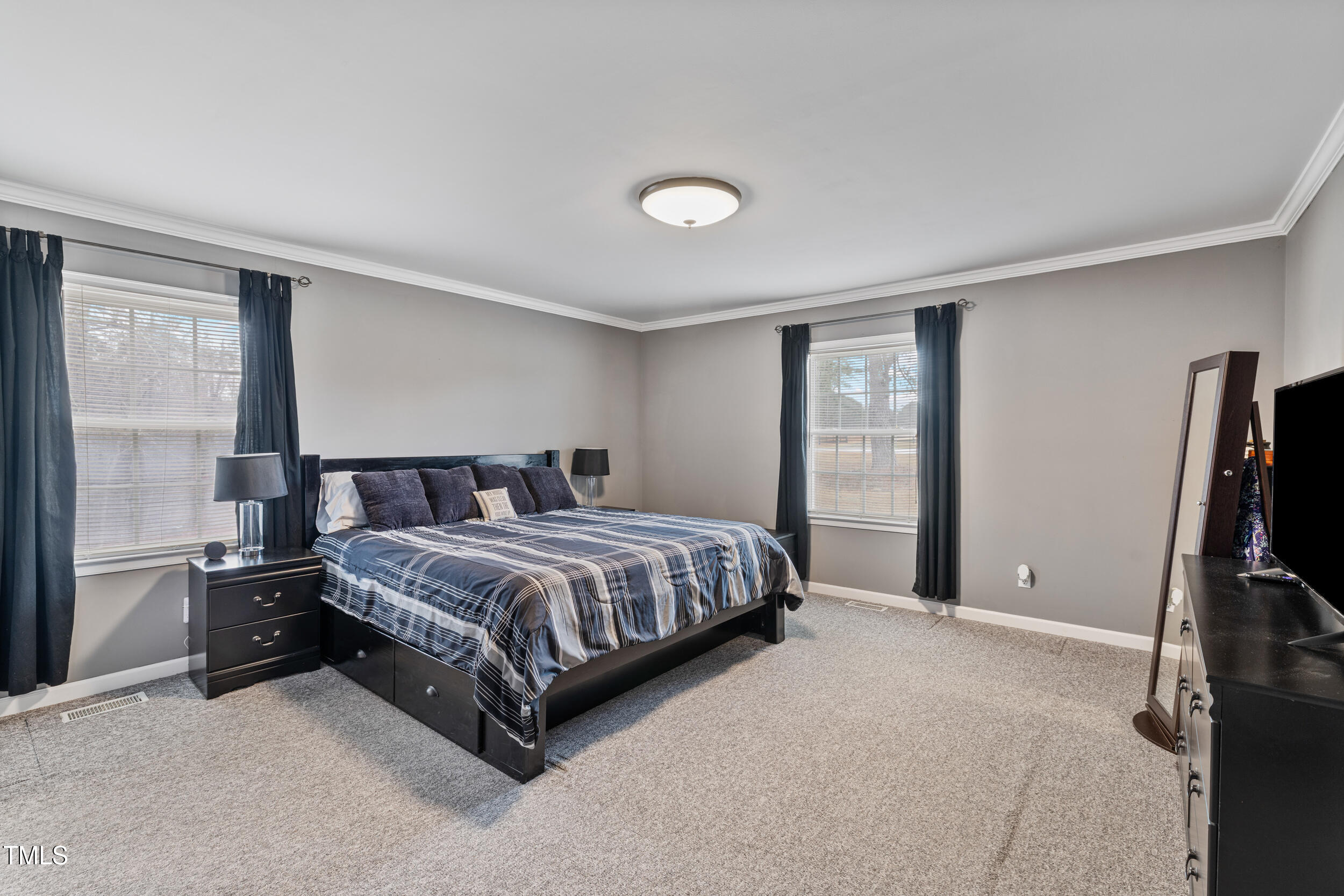 7155 Old Fairground Road Benson, NC 27504 - Photo 12 of 25 a spacious bedroom with a bed and a flat tv screen on dresser