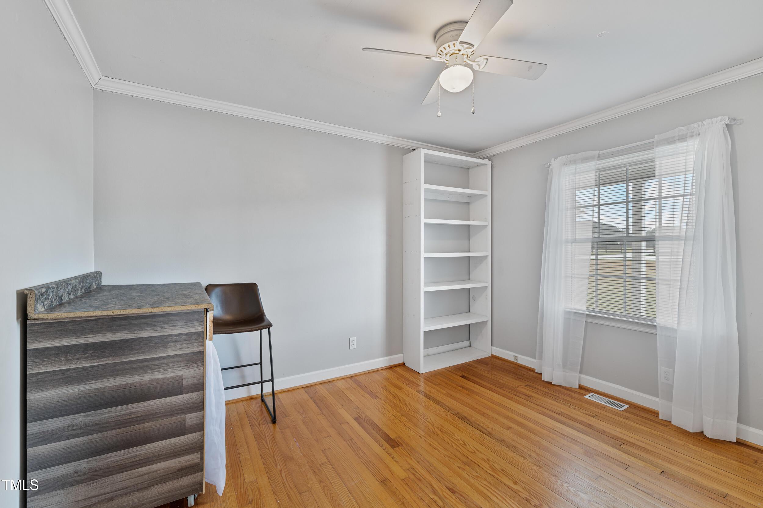 7155 Old Fairground Road Benson, NC 27504 - Photo 17 of 25 a view of empty room with wooden floor and fan