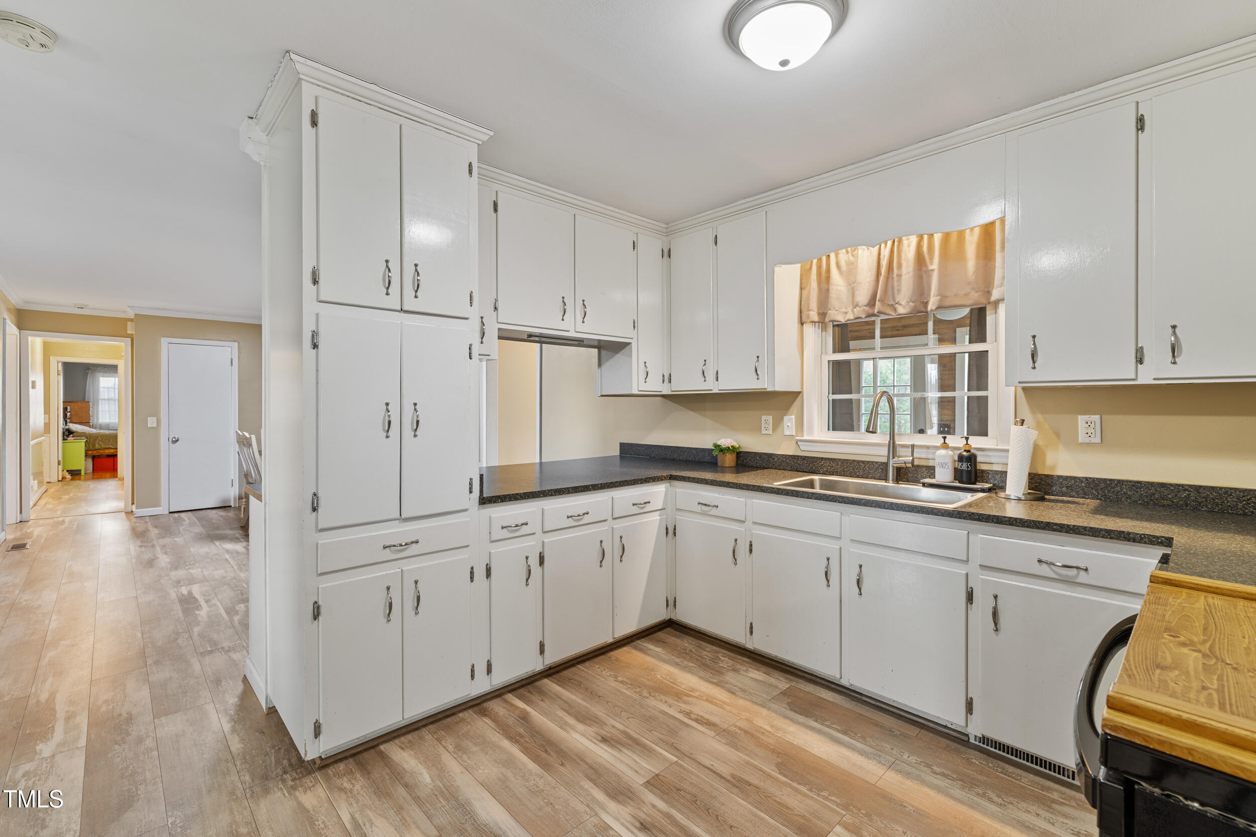 7155 Old Fairground Road Benson, NC 27504 - Photo 7 of 25 a kitchen with granite countertop white cabinets white appliances and sink