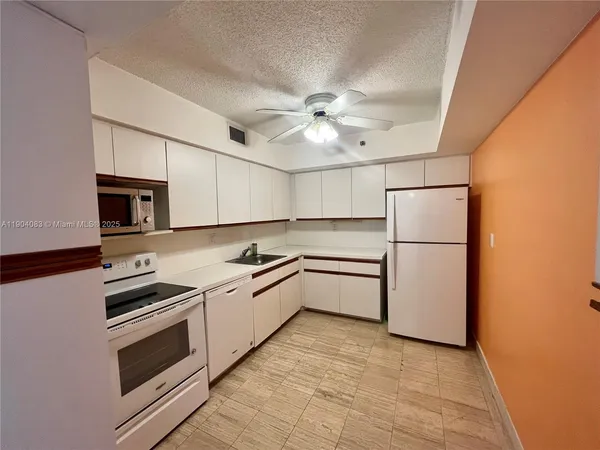 a kitchen with a sink stainless steel appliances and white cabinets