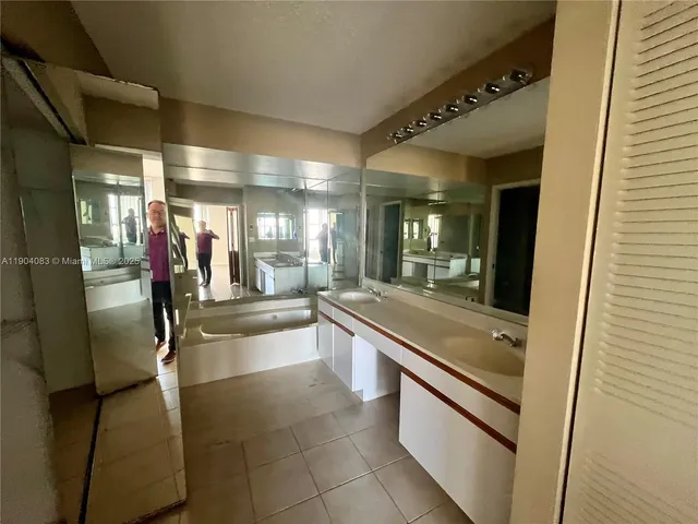 a large bathroom with a large mirror vanity and shower