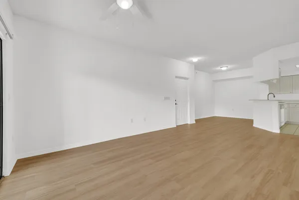 a view of empty room with wooden floor