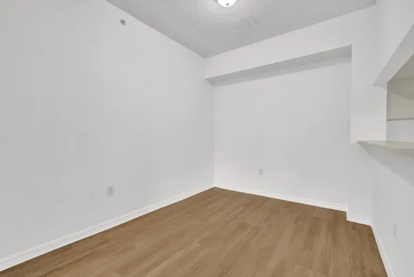a view of an empty room with wooden floor