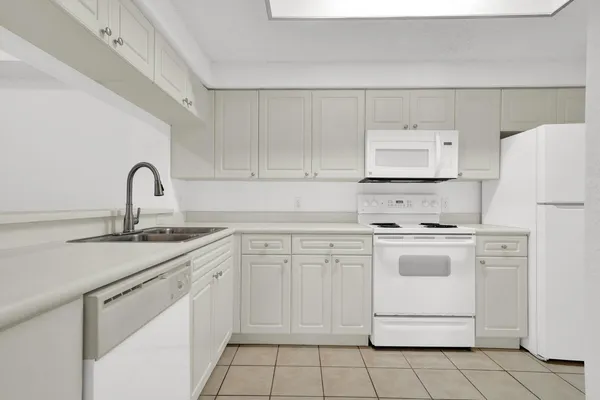 a kitchen with white cabinets appliances and sink