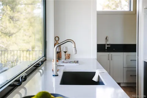 a kitchen with a sink and a stove with wooden floor